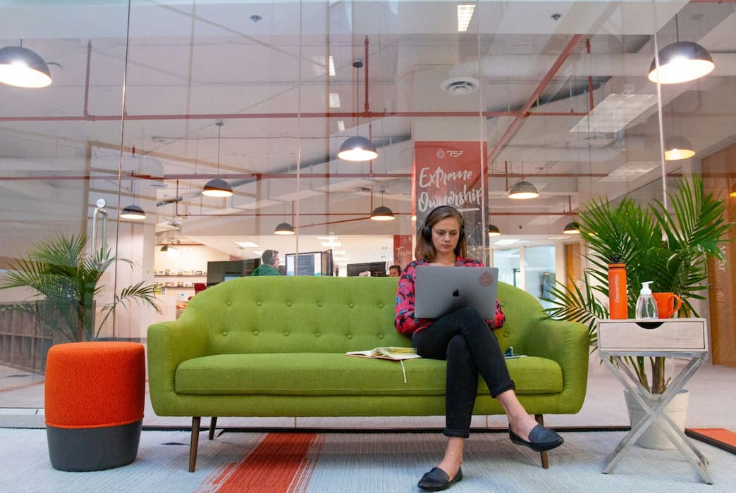 woman sitting on a sofa working on a laptop