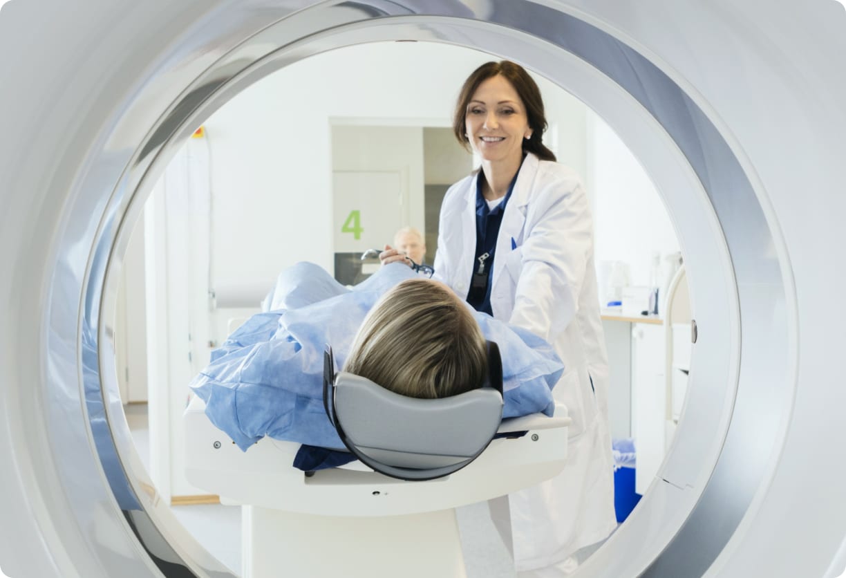 Man sitting on MRI machine smiling